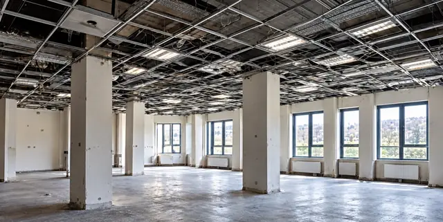 Open-plan office stripped back to columns and an exposed ceiling grid